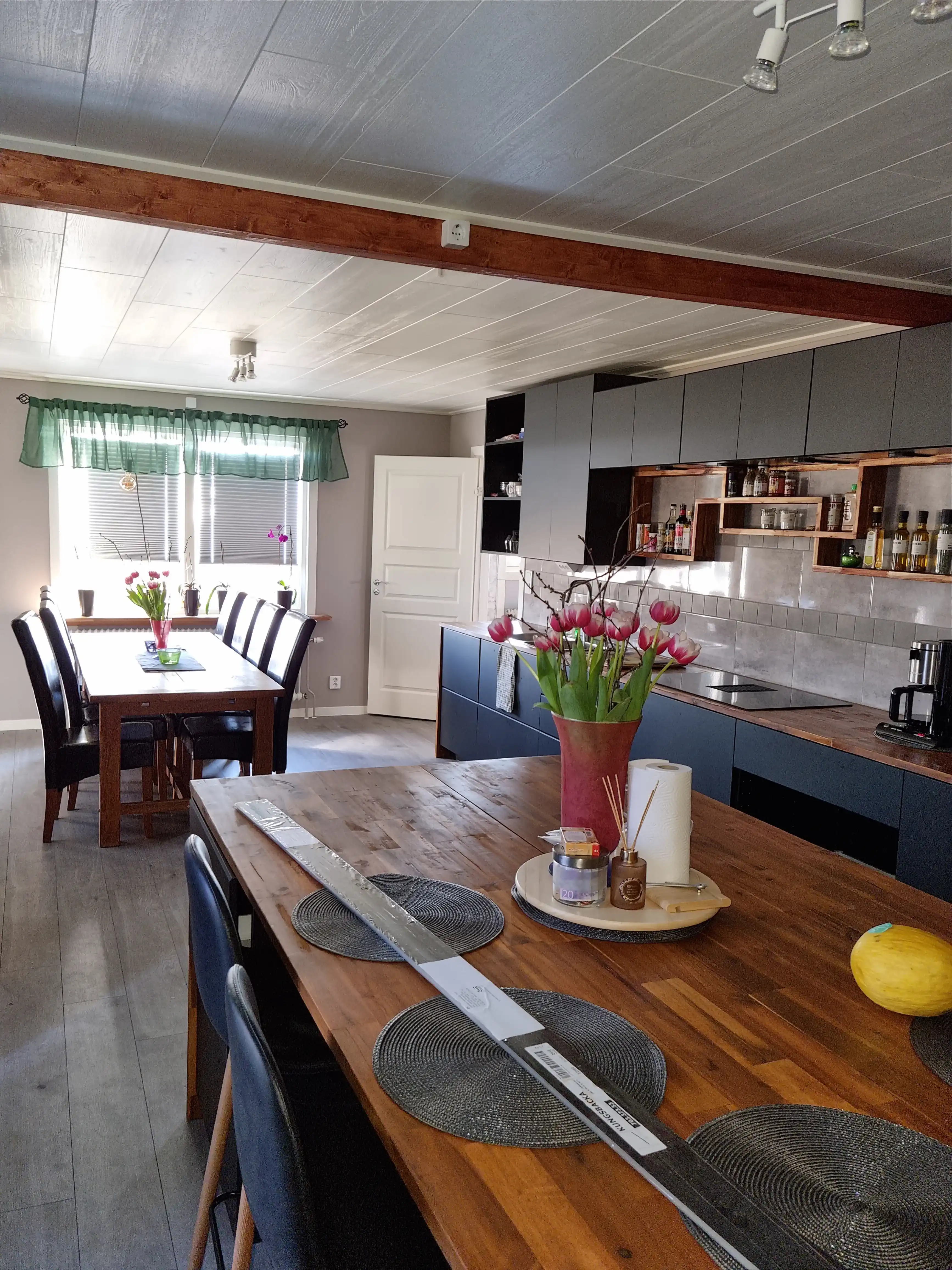 Stor köksrenovering med mörka toner och varma trädetaljer bild 4